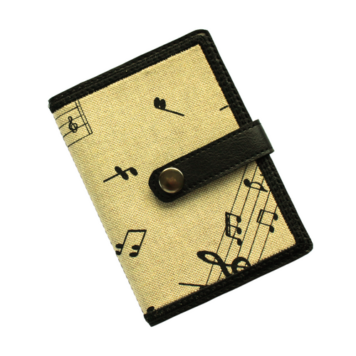 Notebook with musical notes fabric on a beige background stitched on to black faux leather with tab closure and metal rivet fastener